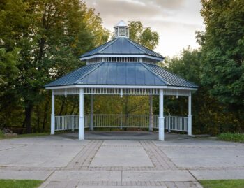 White gazebo with a tiered metal roof, the solid-roof alternative to an open pergola